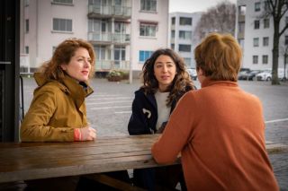 drie vrouwen in gesprek aan een picknicktafel