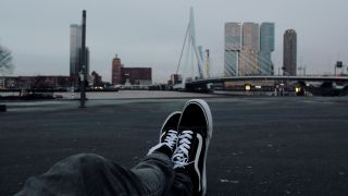 benen met vans schoernen uitkijkend over rotterdam