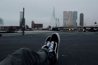 benen met vans schoernen uitkijkend over rotterdam