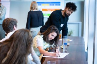 groep in overleg schrijvend aan tafel